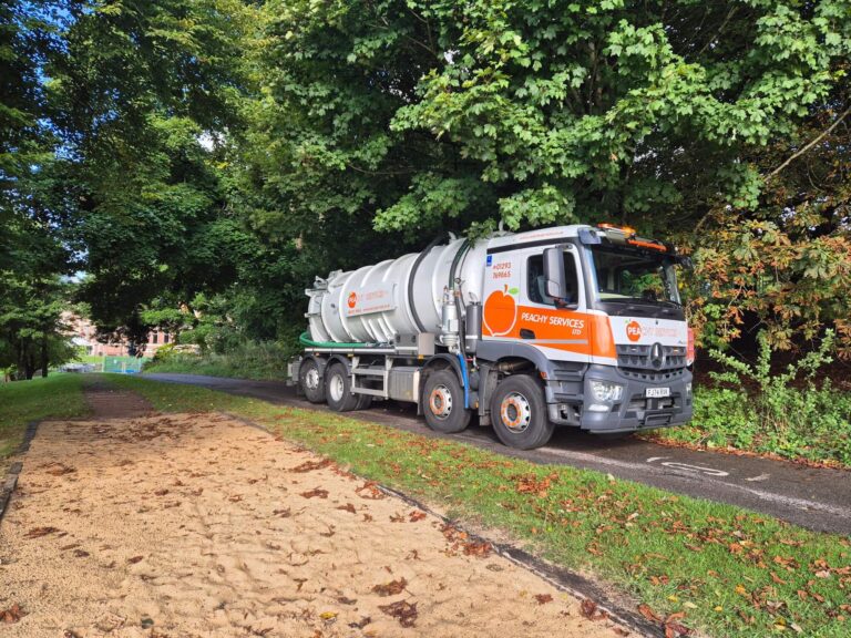 Sewage waste tanker operating down a rural lane in Surrey